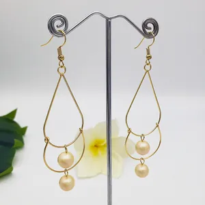 Close-up of golden double-layered pearl drop earrings with elegant tassel design