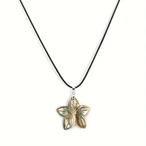 Macro detail of frangipani shell pendant with iridescent luster on black cord necklace