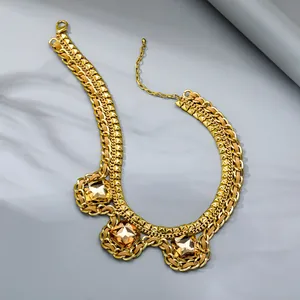 Detail of gold layered chain necklace with three large amber faceted gemstones and studs