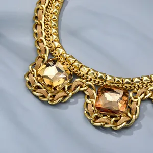 Detailed close-up of double-layer gold chain necklace with amber square zircon accents