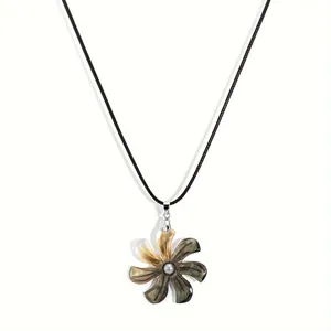 Macro shot of tropical flower pendant with black shell petals and grey pearl center