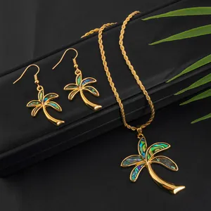 Detailed close-up of gold-plated palm tree jewelry set with iridescent abalone shell inlays