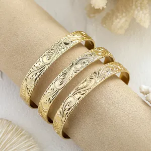 Detailaufnahme von 14k vergoldeten Armreifen mit aufwendiger Gravur und Glanzfinish
