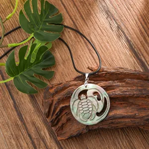 Macro view of shell turtle pendant with natural abalone texture on wooden background