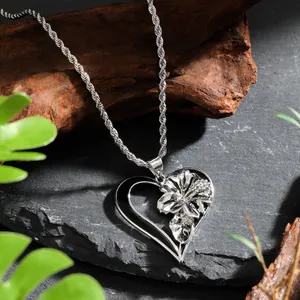 Collier classique avec pendentif cœur et fleur et chaîne torsadée sur roche naturelle