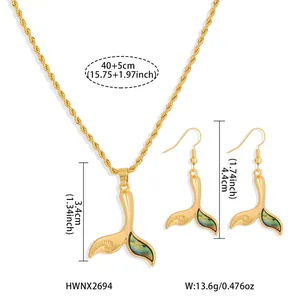 Detailed view of whale tail jewelry set with abalone shell inlay and gold plating