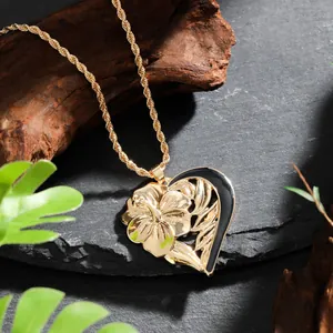 Collier pendentif cœur doré avec gravure de fleur d'hibiscus sur fond de roche sombre