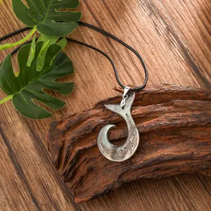 Macro view of shell hook pendant with tribal carvings on a black cord necklace