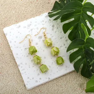 Detail of handmade tulip drop earrings with green gradient flower buds and gold hooks