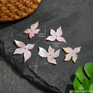 Nahaufnahme der handgeschnitzten Blumenanhänger aus Muschel für DIY Haarschmuck und Ohrringe