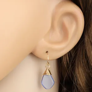 Hellblaue Seeglas-Ohrhänger mit Golddraht am Model für einen natürlichen Schmuckstil