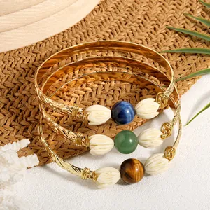 Set of three gold open bangles with tiger eye stones and white jasmine flower details