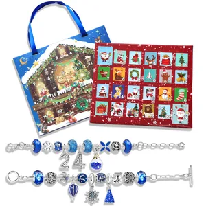 Close-up of DIY Christmas bracelet set with blue beads and a snowy house gift box