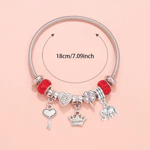 Detailed view of silver charm bracelet featuring crown and elephant pendants with 18cm size