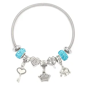 Silver charm bracelet with blue crystal beads, princess crown and heart charms on white background