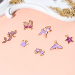 Détail de breloques en émail violet avec formes de sirène, papillon et couronne pour bijoux