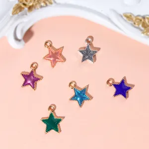 Detail of six colorful star charms with enamel inlay and textured gold or silver borders