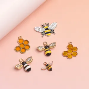 Macro shot of bee and honeycomb charms with rhinestones and enamel for DIY jewelry