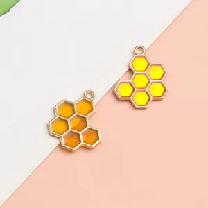 Golden honeycomb bee charms in yellow and orange resin with metal loops for DIY jewelry