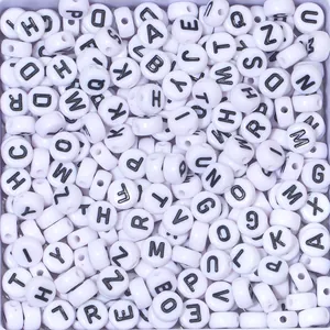 Close-up of 7mm white round luminous letter beads with clear black uppercase alphabet for DIY