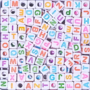 Close-up of white 7mm cubic resin beads with colorful luminous English letters and holes