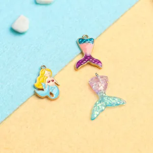 Detailed macro view of mermaid and fishtail alloy charms with colorful enamel and glitter