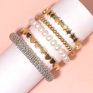 Detail of 5pcs layered bracelet set featuring gold stars, hearts, and faux pearls