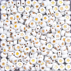 Macro shot of white round resin beads featuring a gold star pattern for DIY crafts