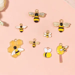 Detailed view of bee and honeycomb charms with rhinestones and colorful enamel