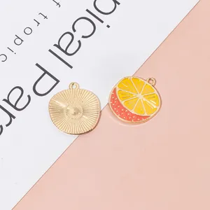 Macro detail of orange slice fruit charms for DIY jewelry with gold metal backing