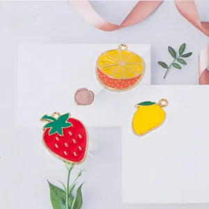 Detailed view of strawberry, orange and lemon enamel fruit charms for DIY jewelry making