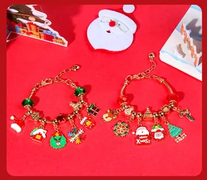 Detail showing two gold Christmas bracelets with Santa and reindeer enamel charms