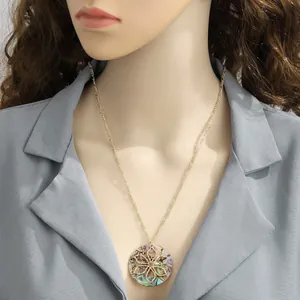 Golden shell pendant necklace with floral cutout design worn by a female model
