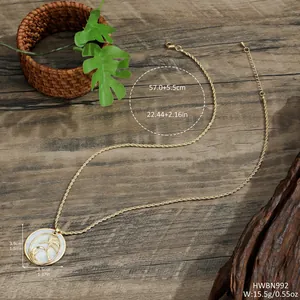 Detailed view of gold necklace with tropical palm tree pendant on wood background