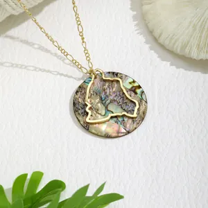 Macro detail of round golden pendant necklace with natural iridescent shell and silhouette
