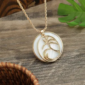 Golden shell necklace with coconut tree pendant on a tropical wooden background