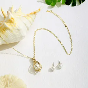Elegantes Schmuckset mit hohlvergoldeter Perlenkette und Perlenohrringen auf weißem Grund