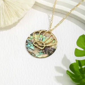 Detail of round gold pendant necklace with natural shell inlay and crown metal overlay