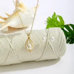 Nahaufnahme eines Perlen-Schmucksets mit hohlem Tropfenanhänger und eleganten Ohrteilen