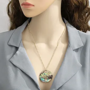 Macro detail of round abalone shell pendant with golden crown accent on mannequin