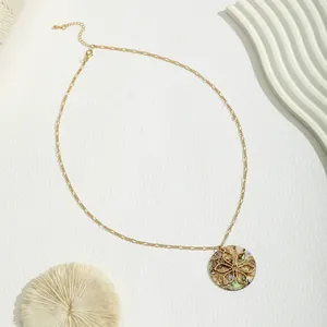 Golden round necklace featuring a natural shell pendant with floral openwork overlay