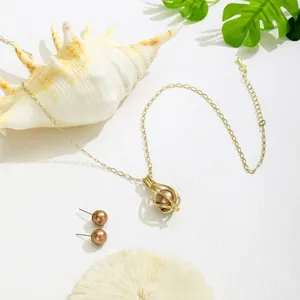 Elegantes Schmuckset mit hohlgearbeitetem Perlenanhänger und passenden Ohrsteckern