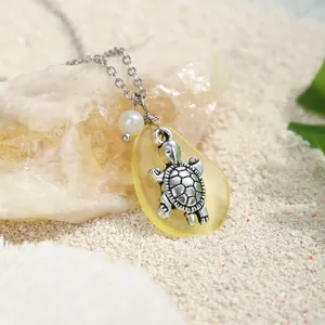 Ciondolo a tartaruga in argento con vetro marino giallo e perla sulla sabbia