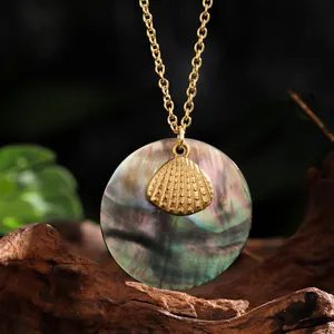 Collier en acier doré avec pendentif rond en nacre noire et petit détail de coquillage