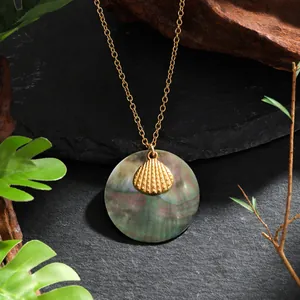 Vue détaillée du pendentif coquillage avec métal doré et reflets irisés arc-en-ciel