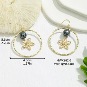 Détail macro de boucles fleurs dorées avec perle grise indiquant 5,6 cm de hauteur