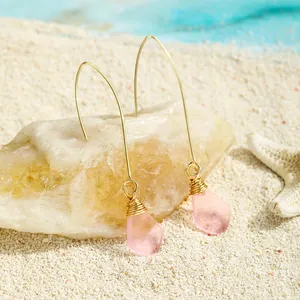 Nahaufnahme handgefertigter rosa Meerglas-Ohrhänger mit Golddrahtwicklung im Detail