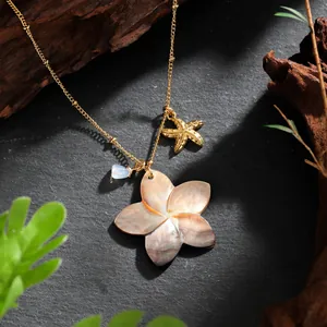 Detail of Hawaiian style necklace with shell flower, golden starfish and blue bead pendant