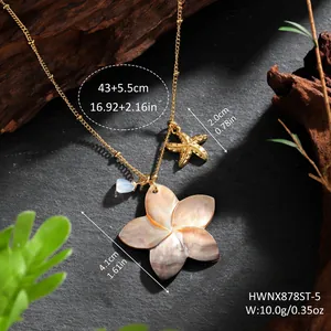 Detail of shell flower necklace and golden starfish pendant on textured stone background