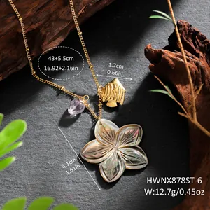 Detailed view of Hawaiian shell flower necklace with golden fish and purple gem pendants